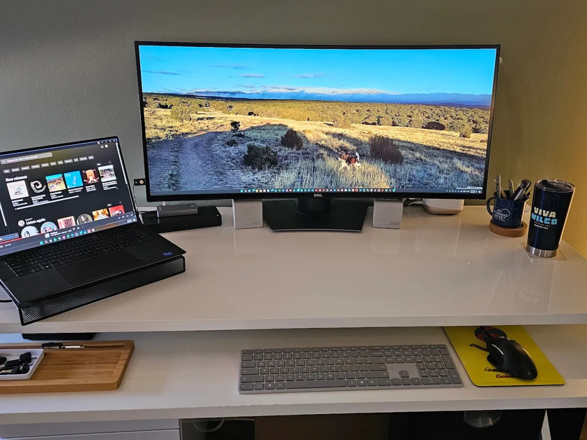 A desktop computer and a laptop set up side by side on a desk